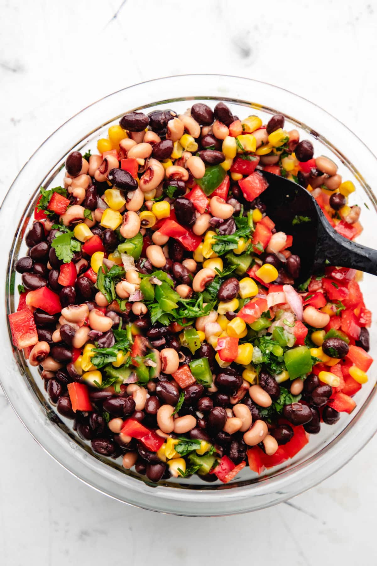 Cowboy Caviar A black spoon in a glass bowl of cowboy caviar.