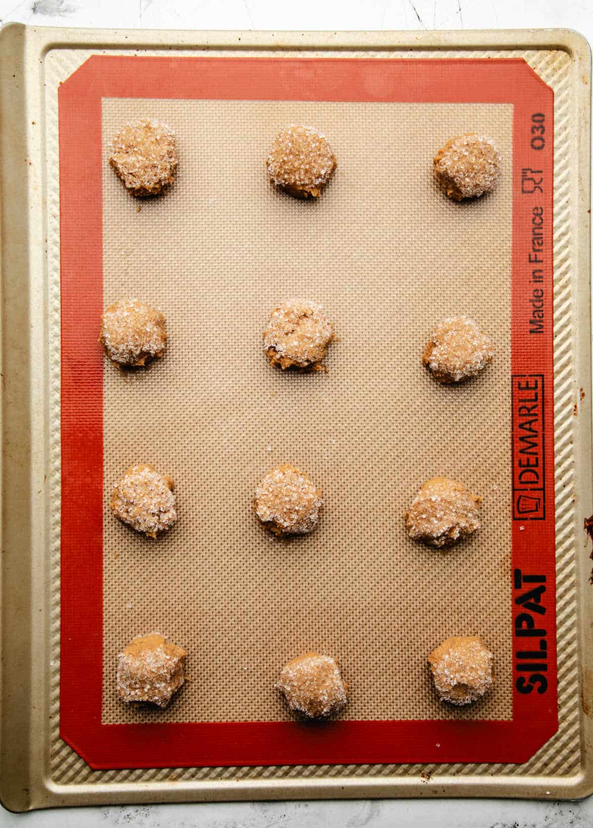 Ginger molasses cookie dough on a baking sheet. 