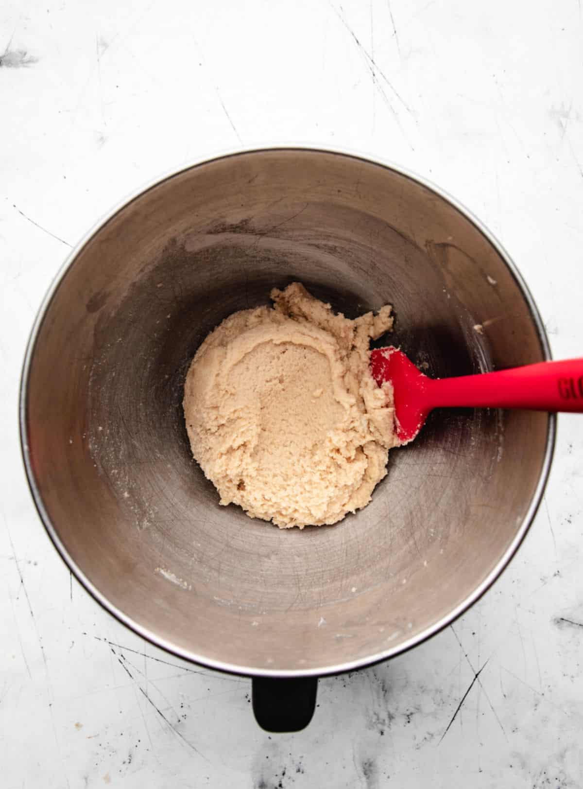 Butter and sugars creamed in a silver mixing bowl. 