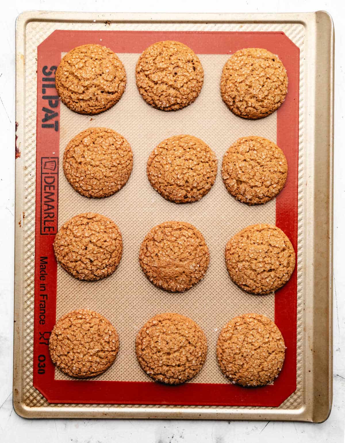 Baked ginger molasses cookies on a baking sheet. 