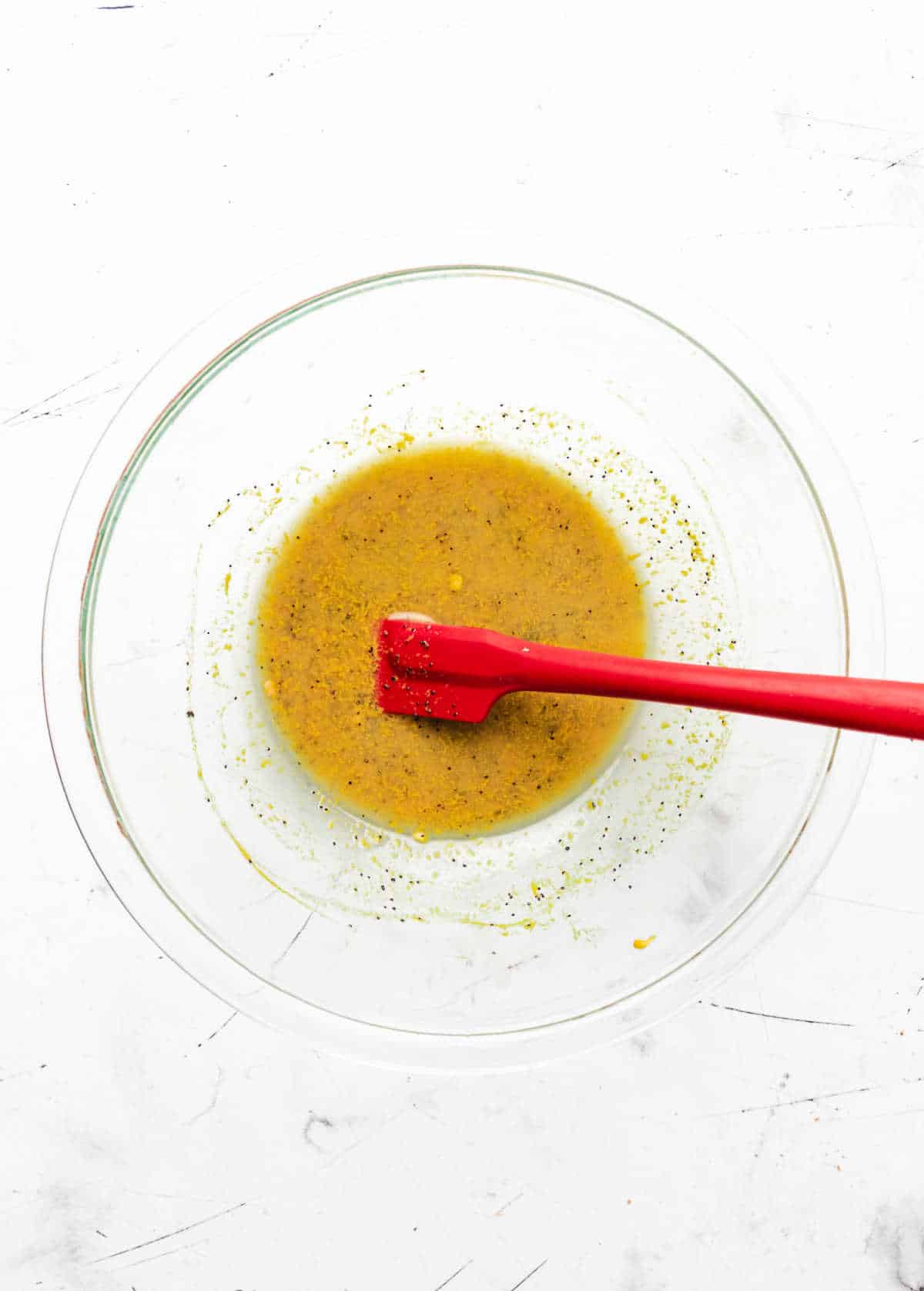 Butter poppy seed mixture in a glass mixing bowl. 