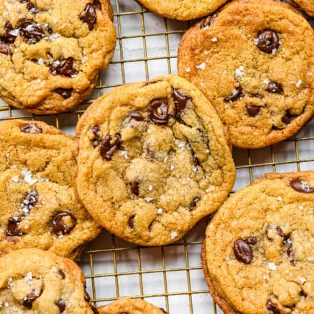 Chewy chocolate chip cookies overlapping on a wire cooling rack.