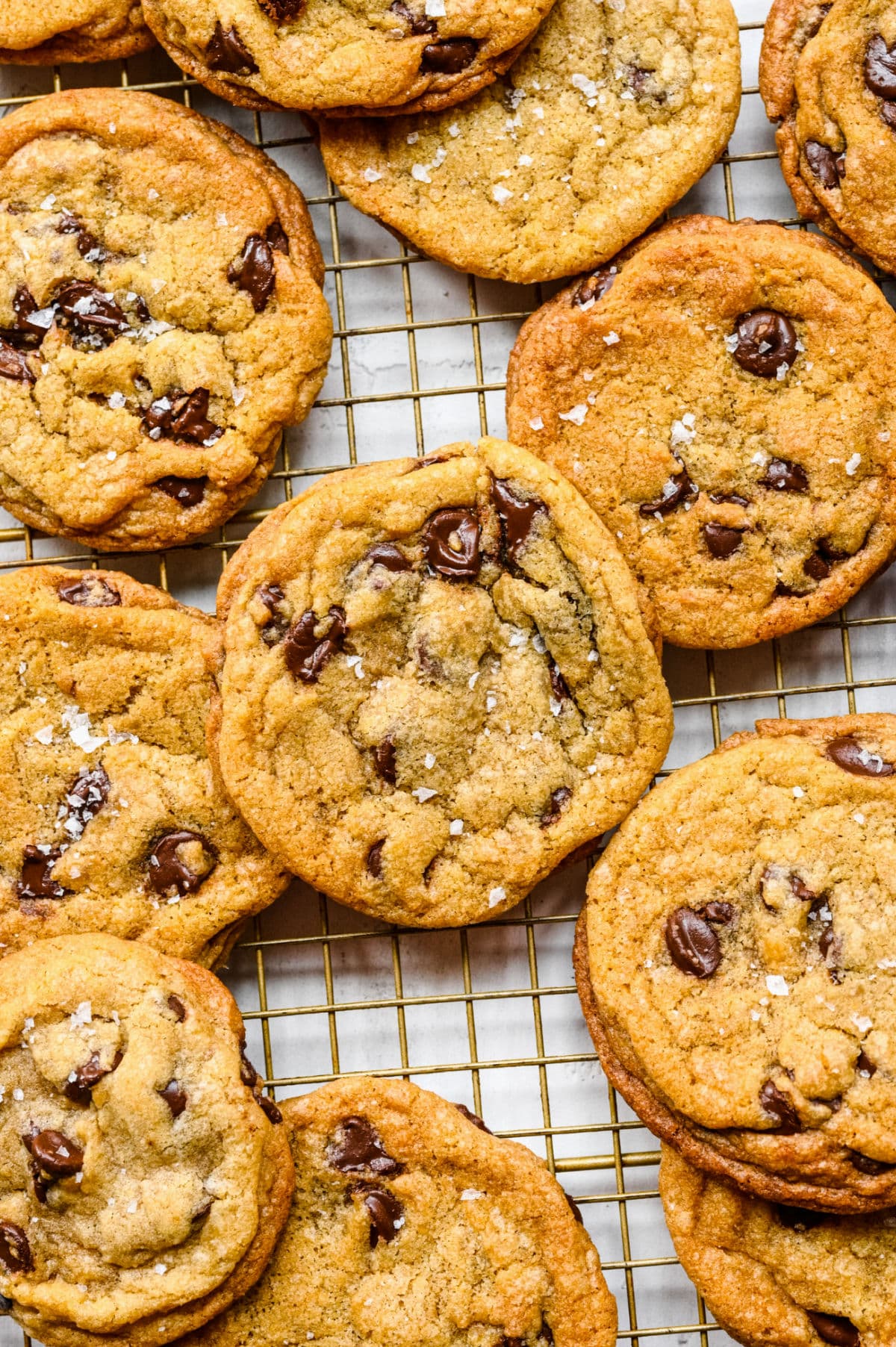 Chewy chocolate chip cookies overlapping on a wire cooling rack.