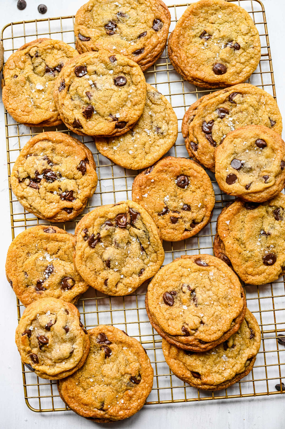 Stacks of chewy chocolate chip cookies on a wire cooling rack.