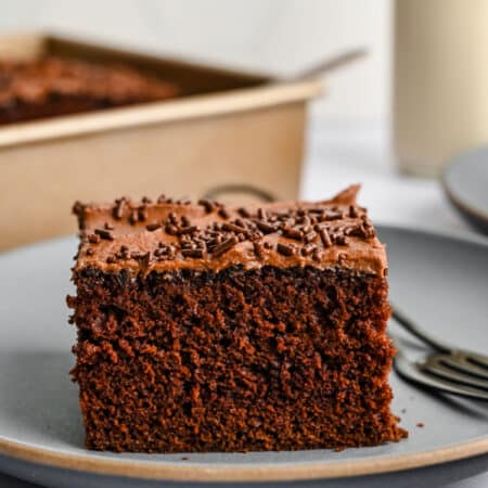 A piece of chocolate mayonnaise cake on a plate with a fork next to it.