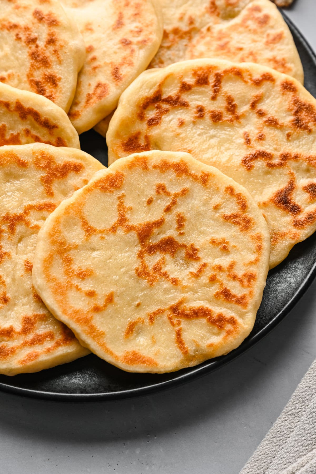 Close up photo of a homemade flatbread on a dark plate. 