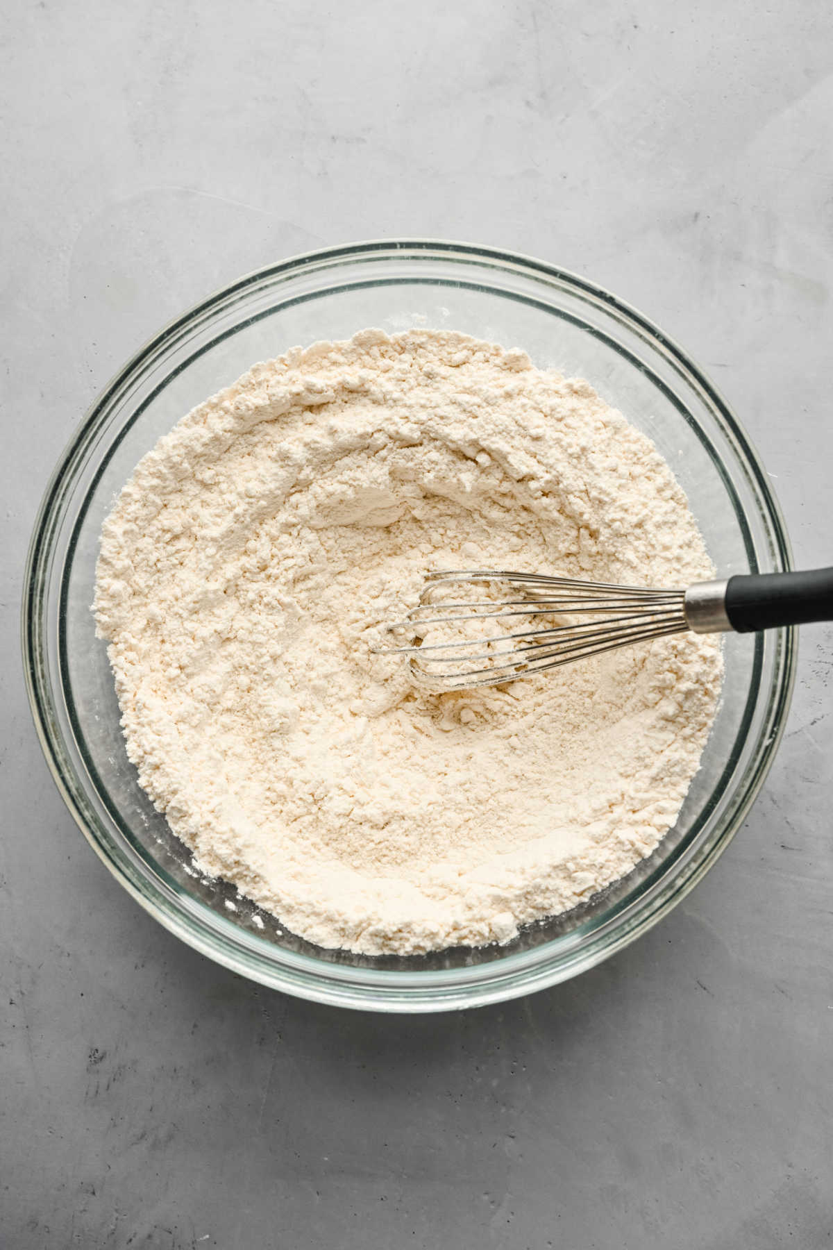 Flour and salt whisked together in a glass mixing bowl. 