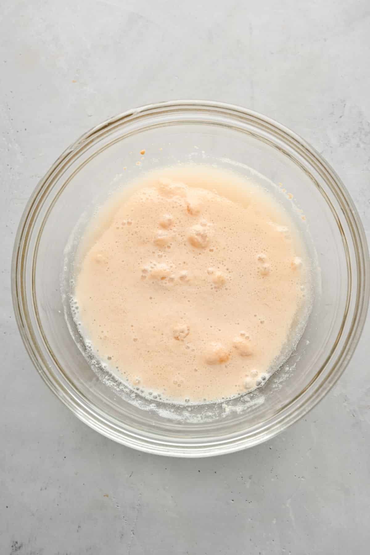 Yeast proofing in a glass mixing bowl. 