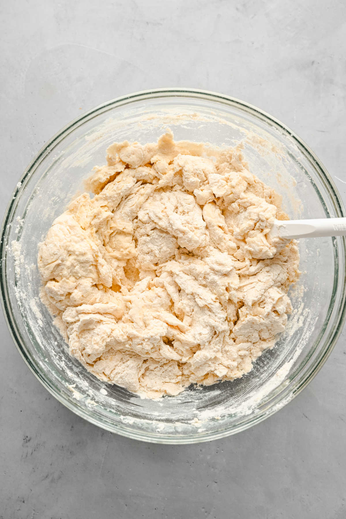 Ingredients for flatbread being stirred together in a glass mixing bowl. 