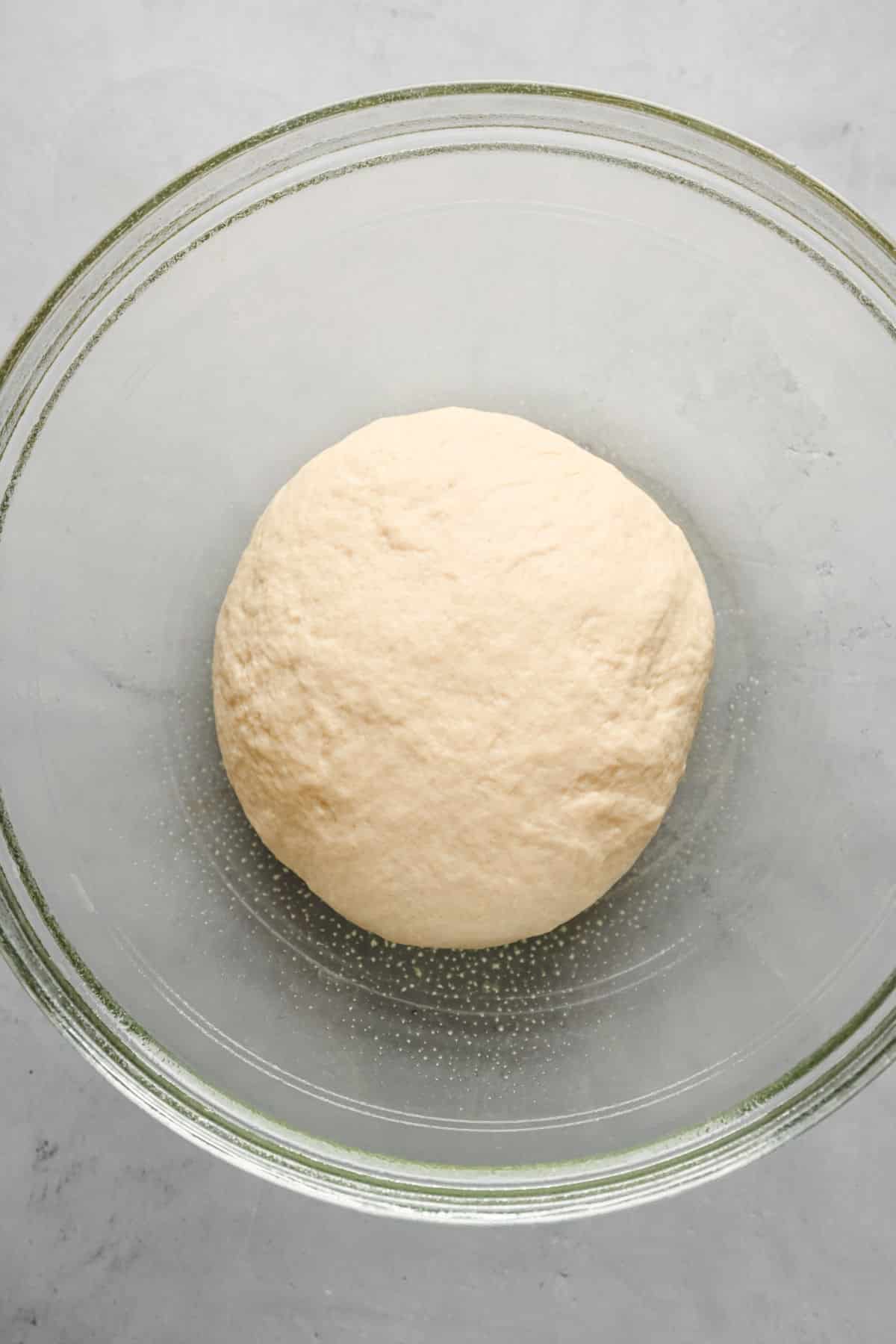 Flatbread dough in a glass mixing bowl. 