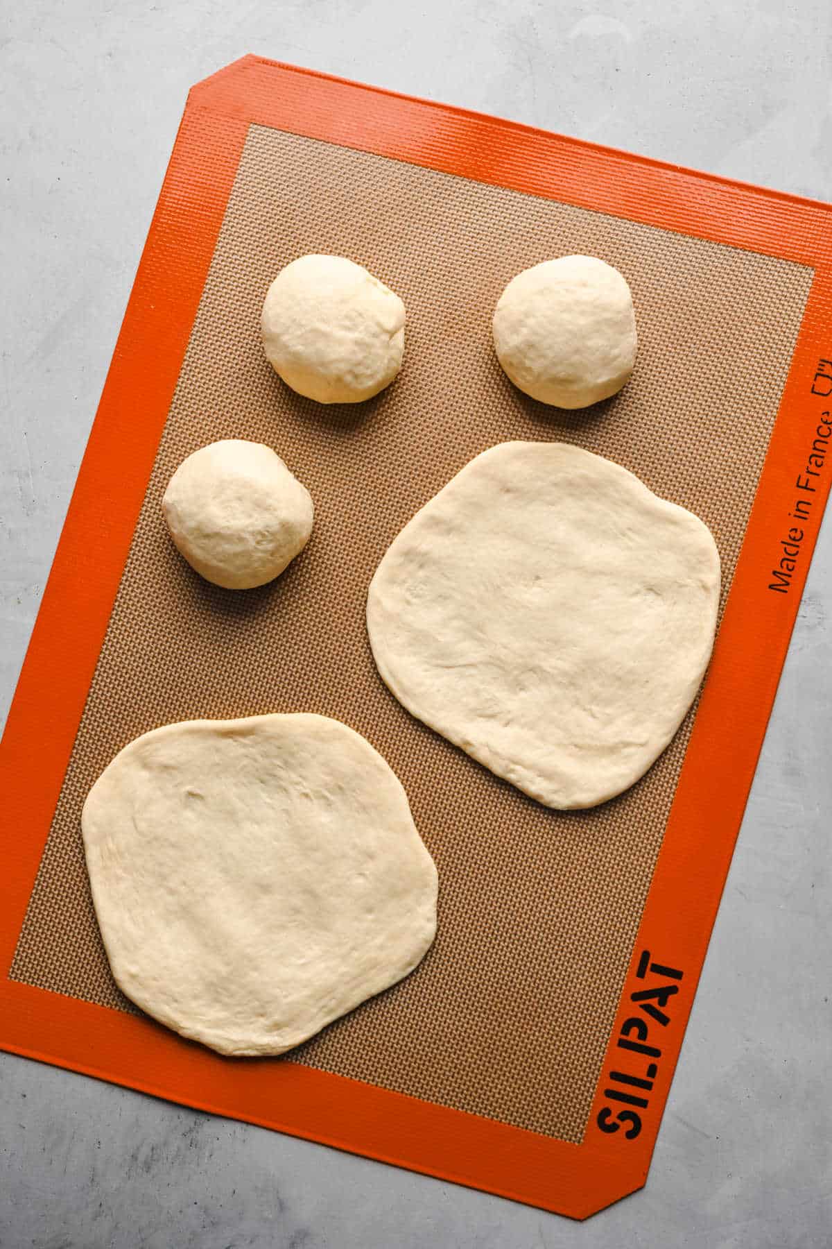 Balls of flatbread dough flattened into a circle. 