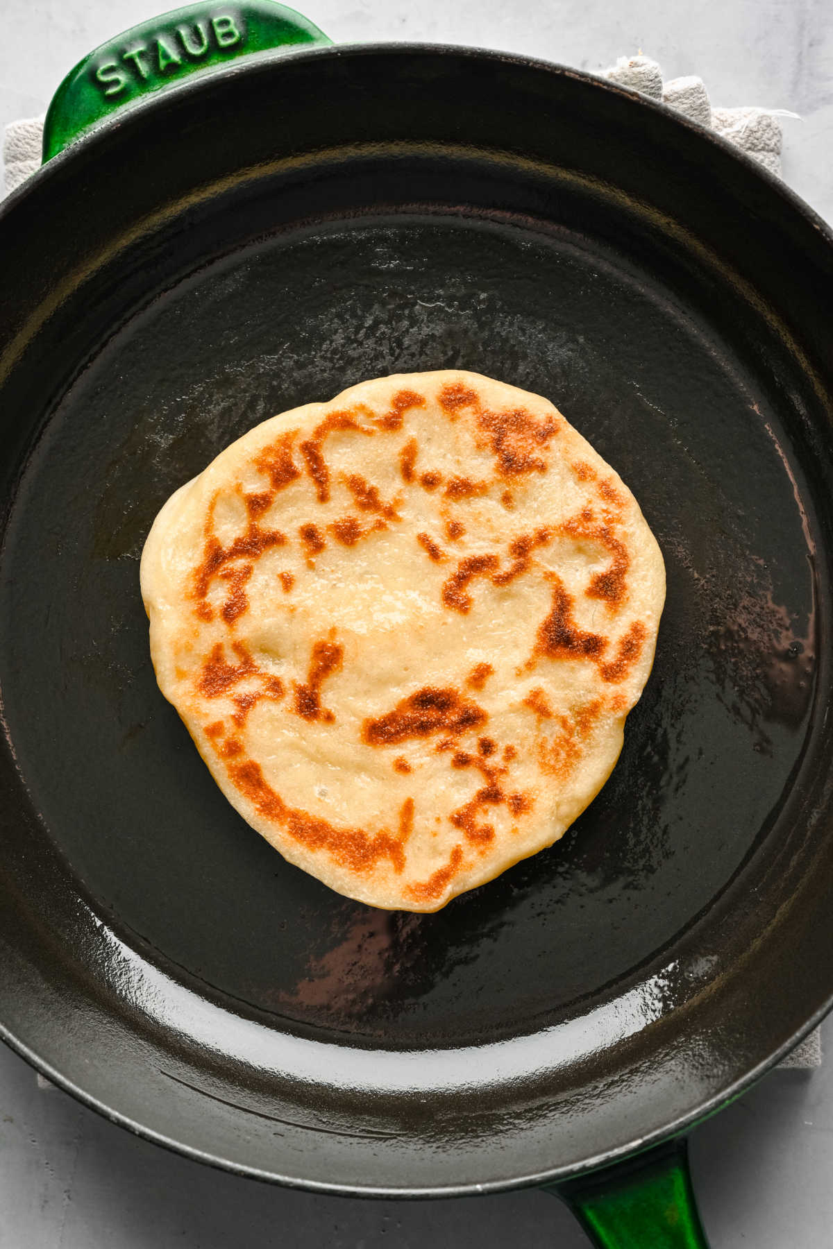 A flatbread cooking in a skillet. 