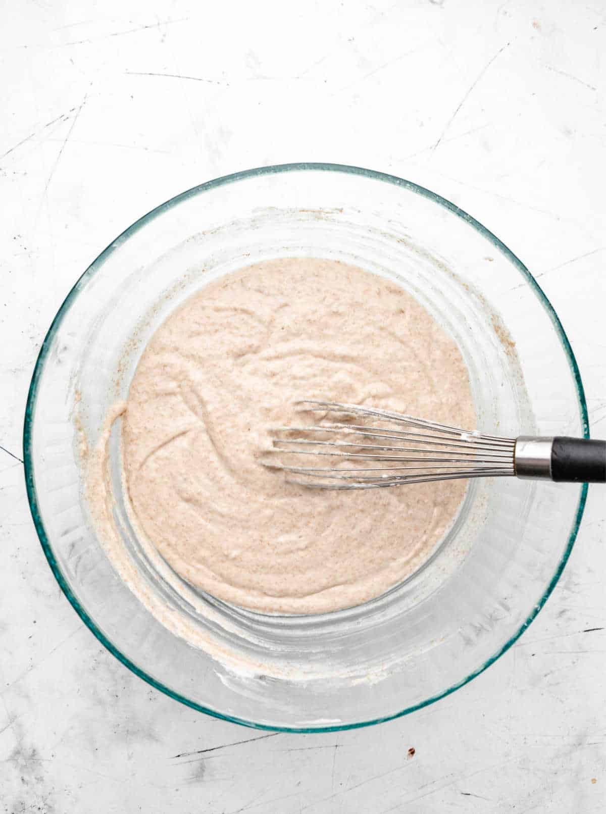 Greek yogurt muffin batter in a glass mixing bowl. 