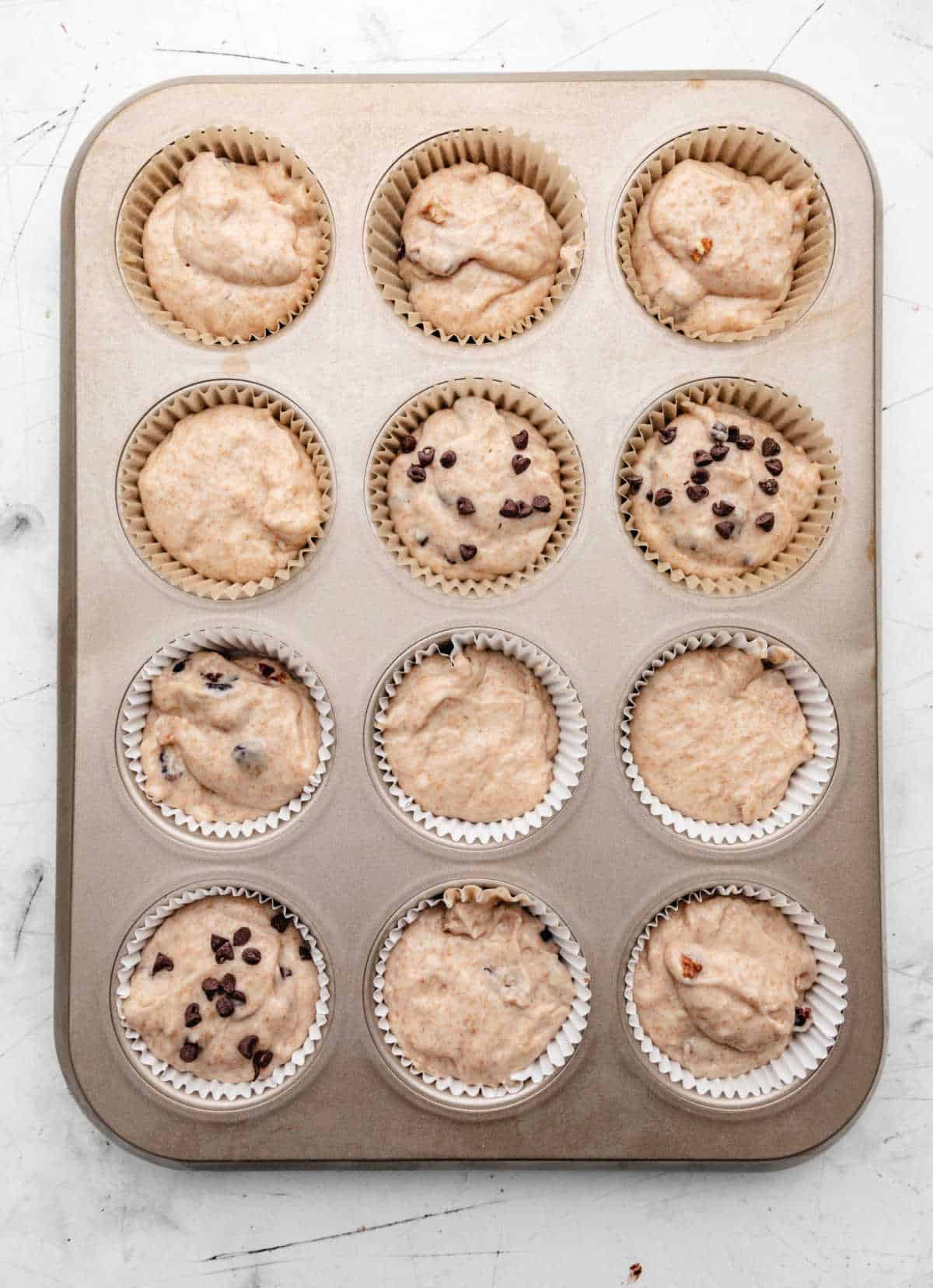 Greek yogurt muffin batter in a muffin tin.