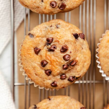 A row of Greek yogurt muffins on a wire cooling rack.