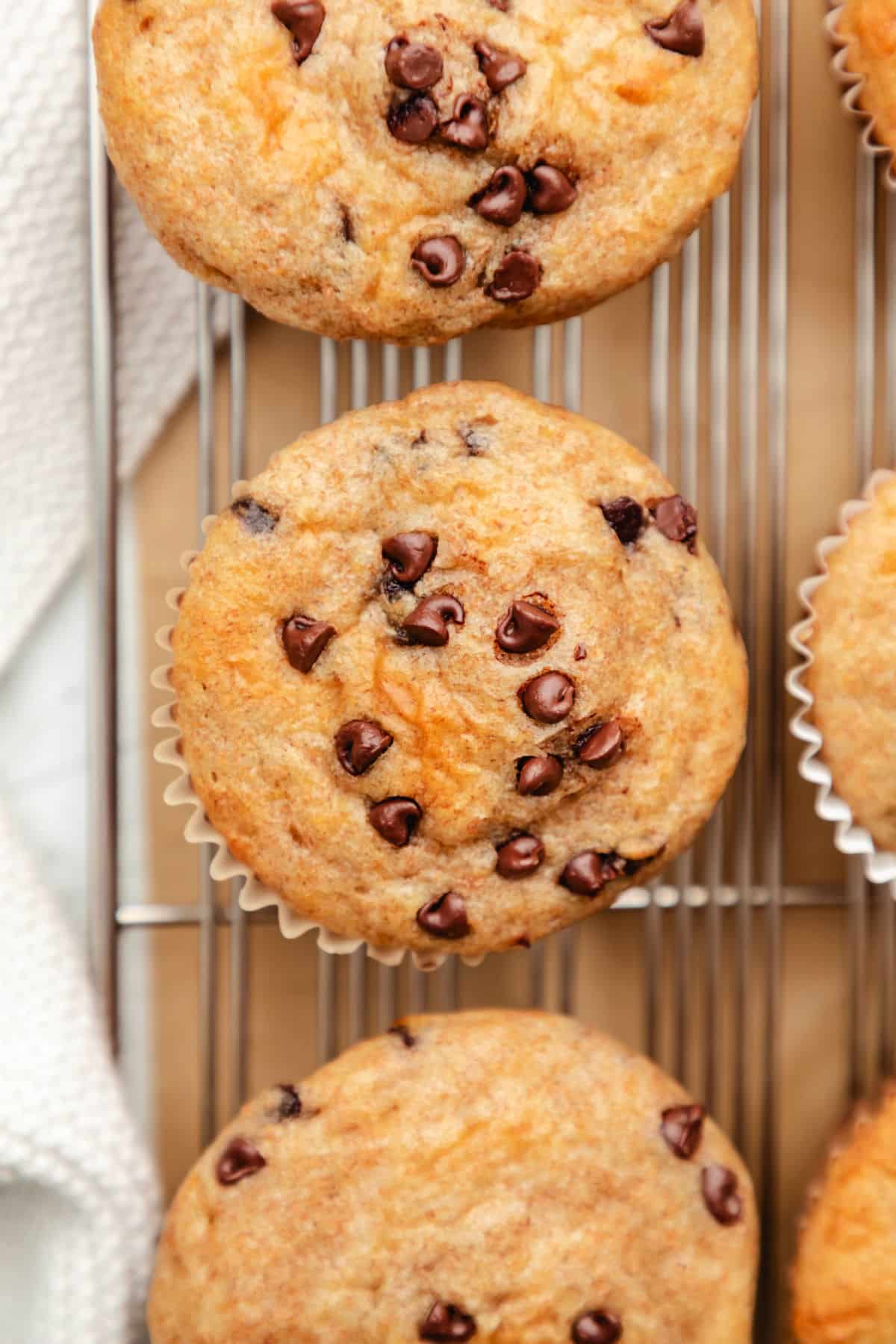 A row of Greek yogurt muffins on a wire cooling rack.