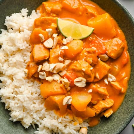 A dish of chicken massaman curry over sticky rice.