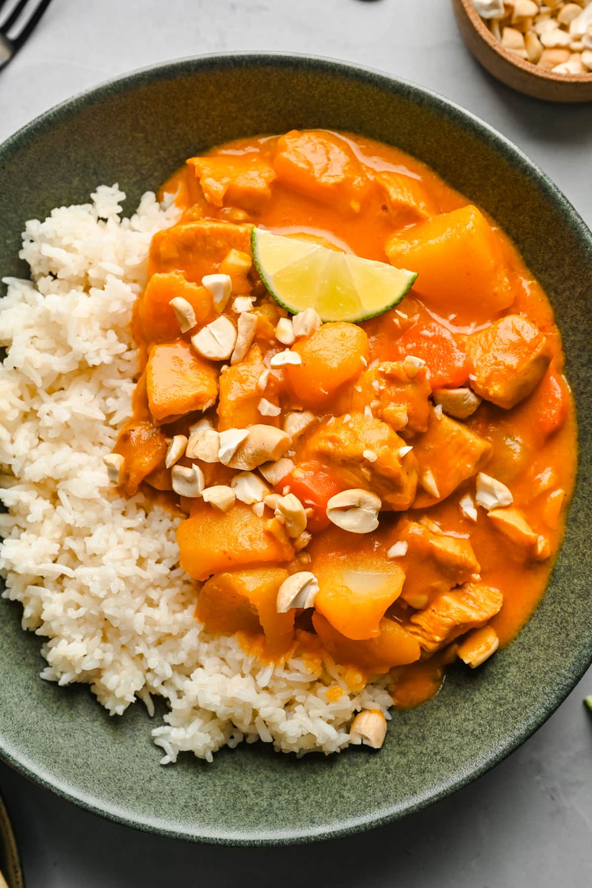 A dish of chicken massaman curry over sticky rice. 