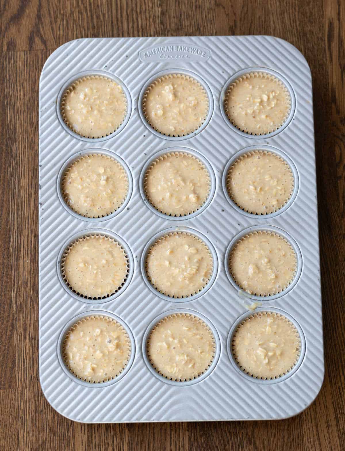 Oatmeal muffin batter in a muffin tin.