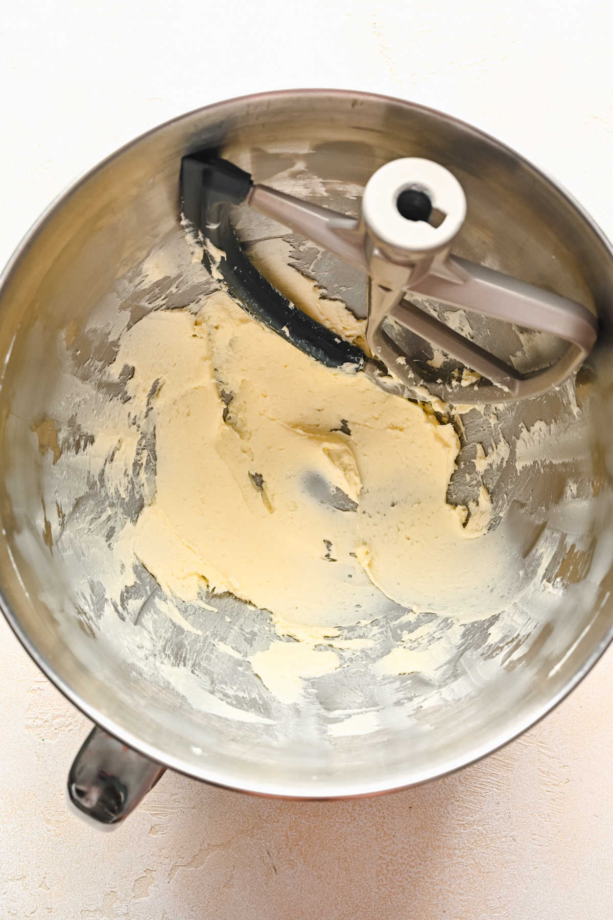 Beaten butter in a silver mixing bowl. 