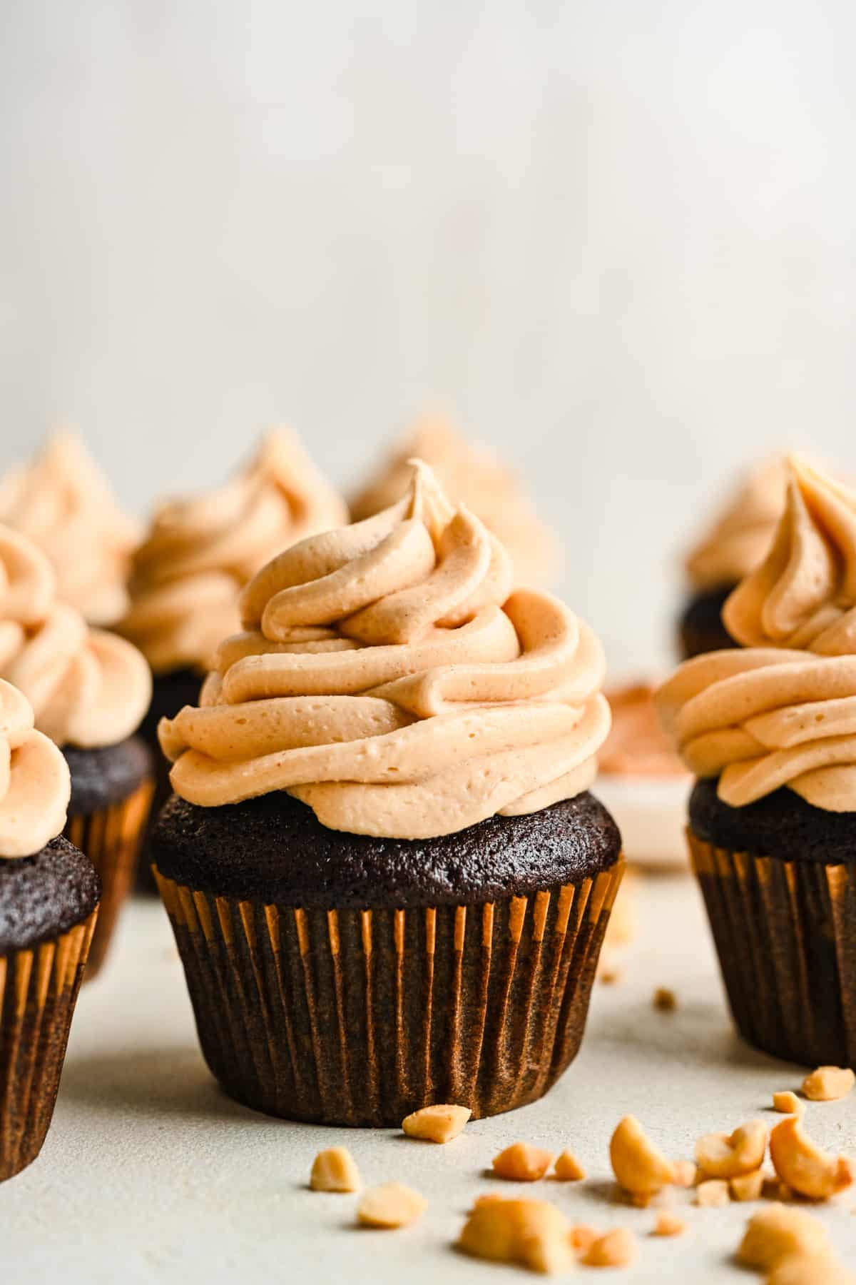 Peanut butter frosting on rows of chocolate cupcakes.