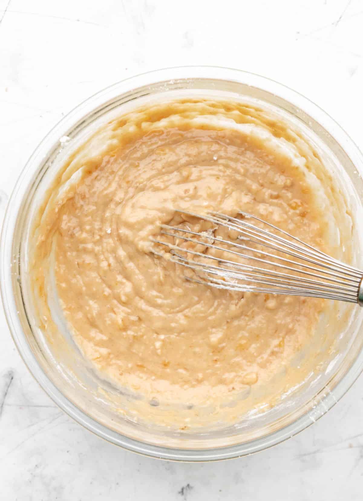 Banana nut bread batter in a glass mixing bowl. 