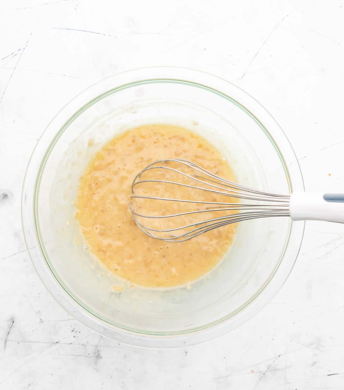 Mashed banana whisked into egg and oil mixture. 