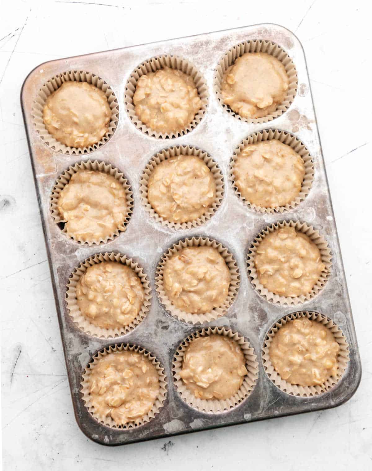 Banana oatmeal muffin batter in a muffin tin.