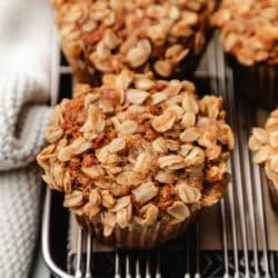 Banana oatmeal muffins in a row on a cooling rack.