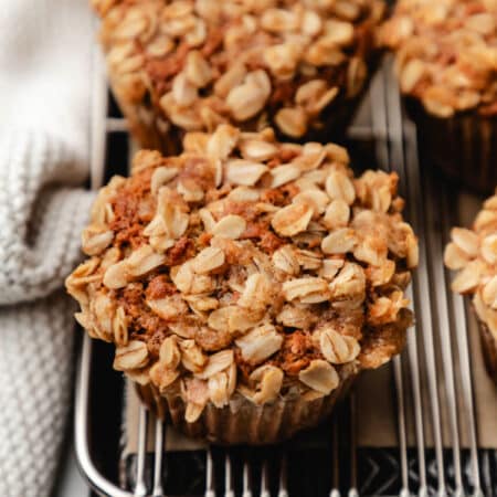 Banana oatmeal muffins in a row on a cooling rack.
