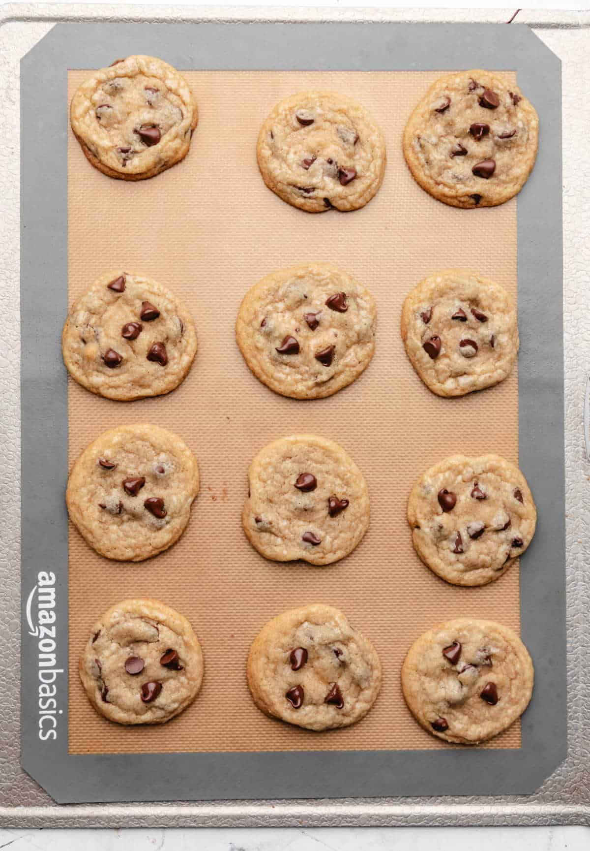 Baked coconut oil chocolate chip cookies on a baking sheet. 