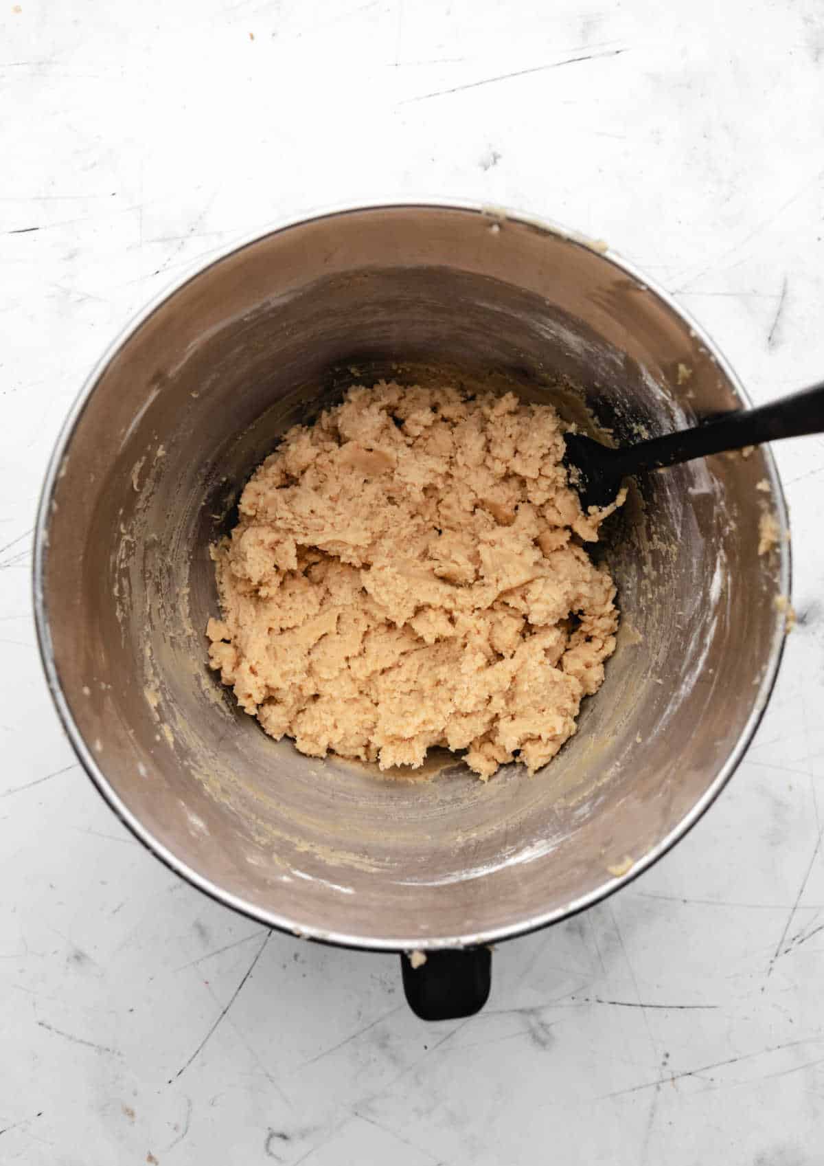 Dry ingredients stirred into wet ingredients for coconut oil chocolate chip cookies. 