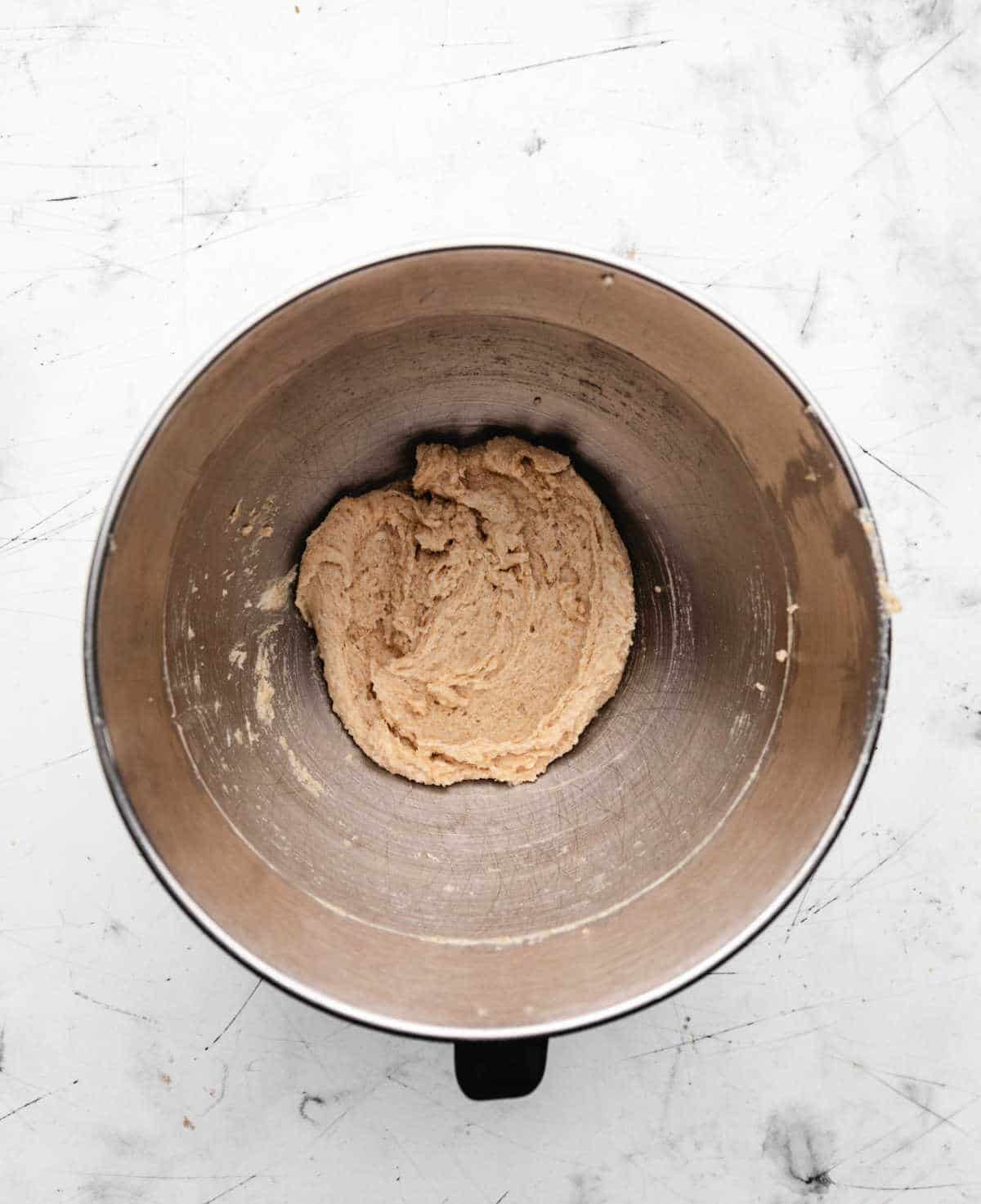 Creamed coconut oil and sugars in a mixing bowl.