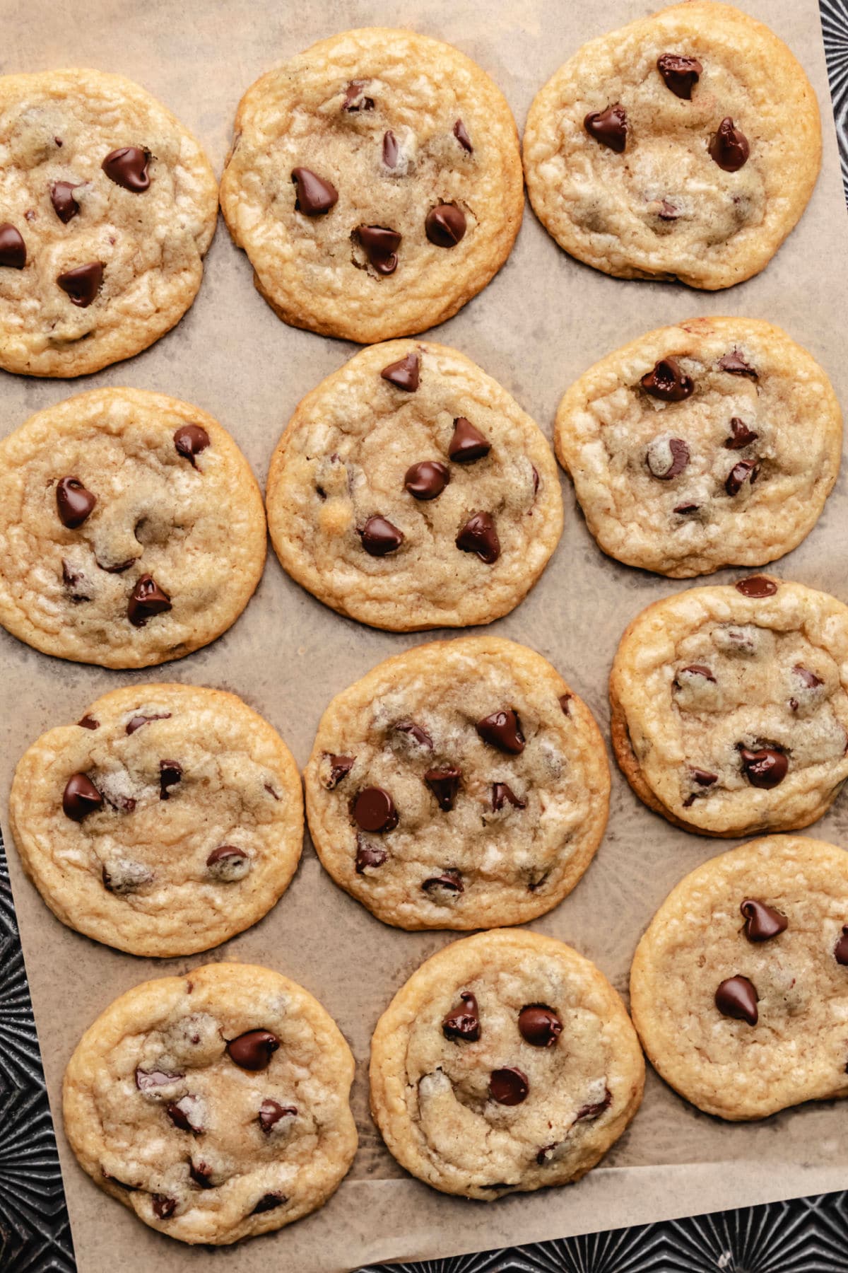 Coconut oil chocolate chip cookies on a sheet of brown parchment paper. 