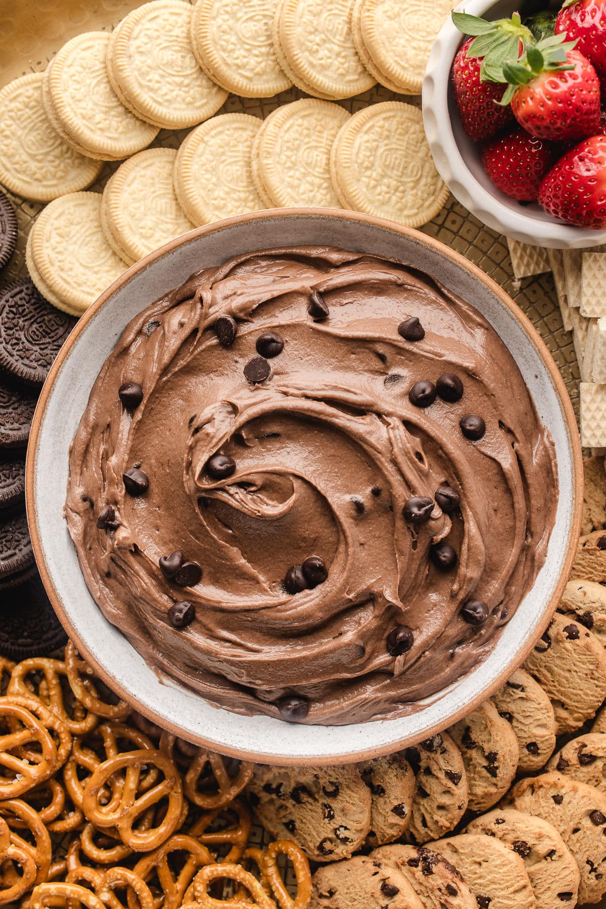 A dish of brownie batter dip topped with mini chocolate chips.