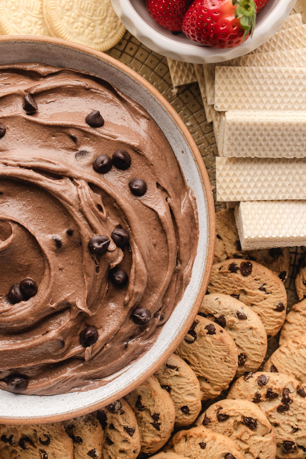 Close up photo of brownie batter dip next to wafer cookies and chocolate chip cookies.