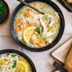 Two black bowls filled with lemon chicken and rice soup.