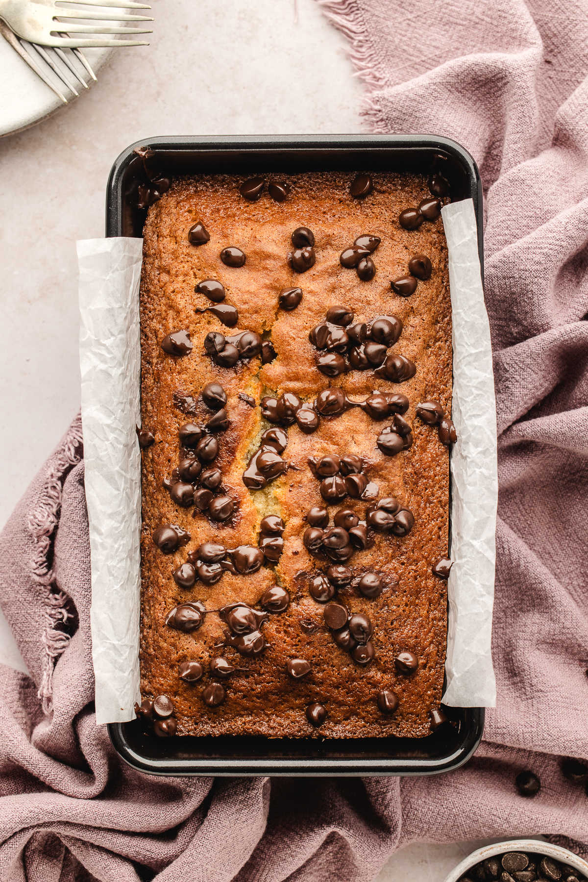 A baked chocolate chip loaf cake in the pan.
