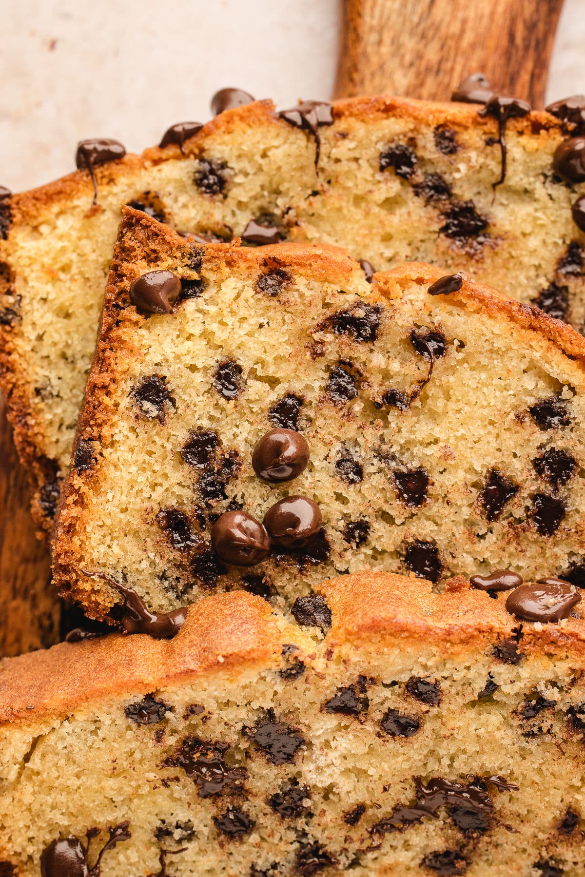 Slices of chocolate chip loaf cake topped with melting chocolate chips. 