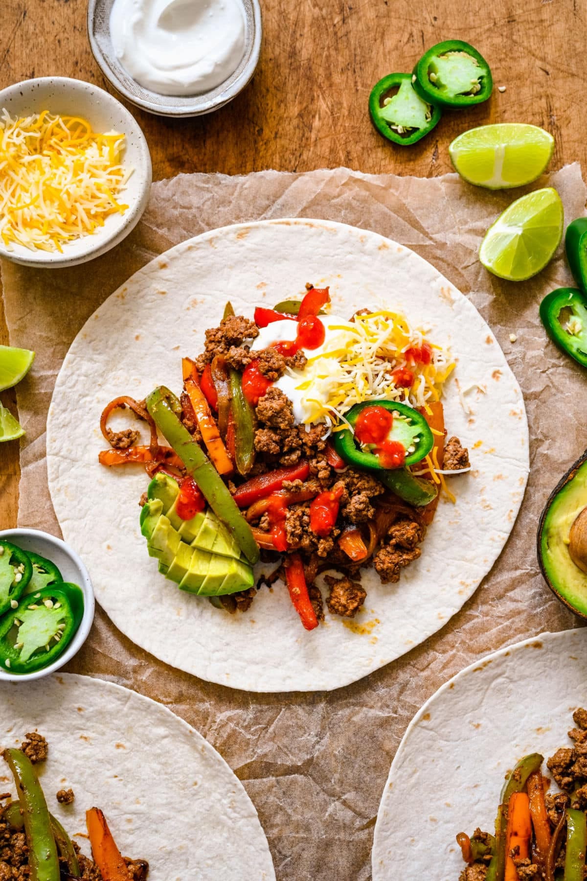 Ground beef fajitas topped with cheese avocado and jalapeno on a flour tortilla.