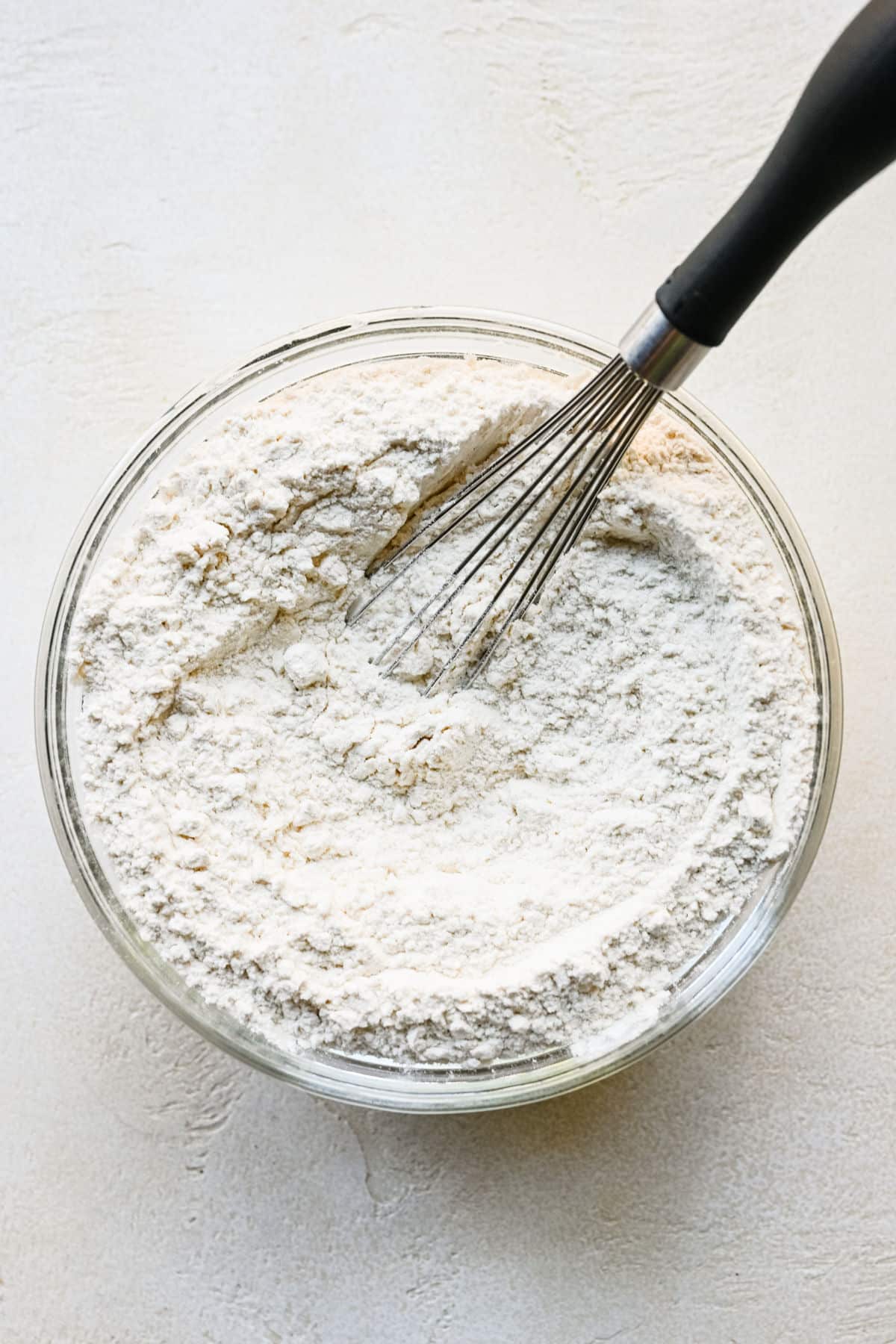 Dry ingredients for lemon sugar cookies in a bowl.