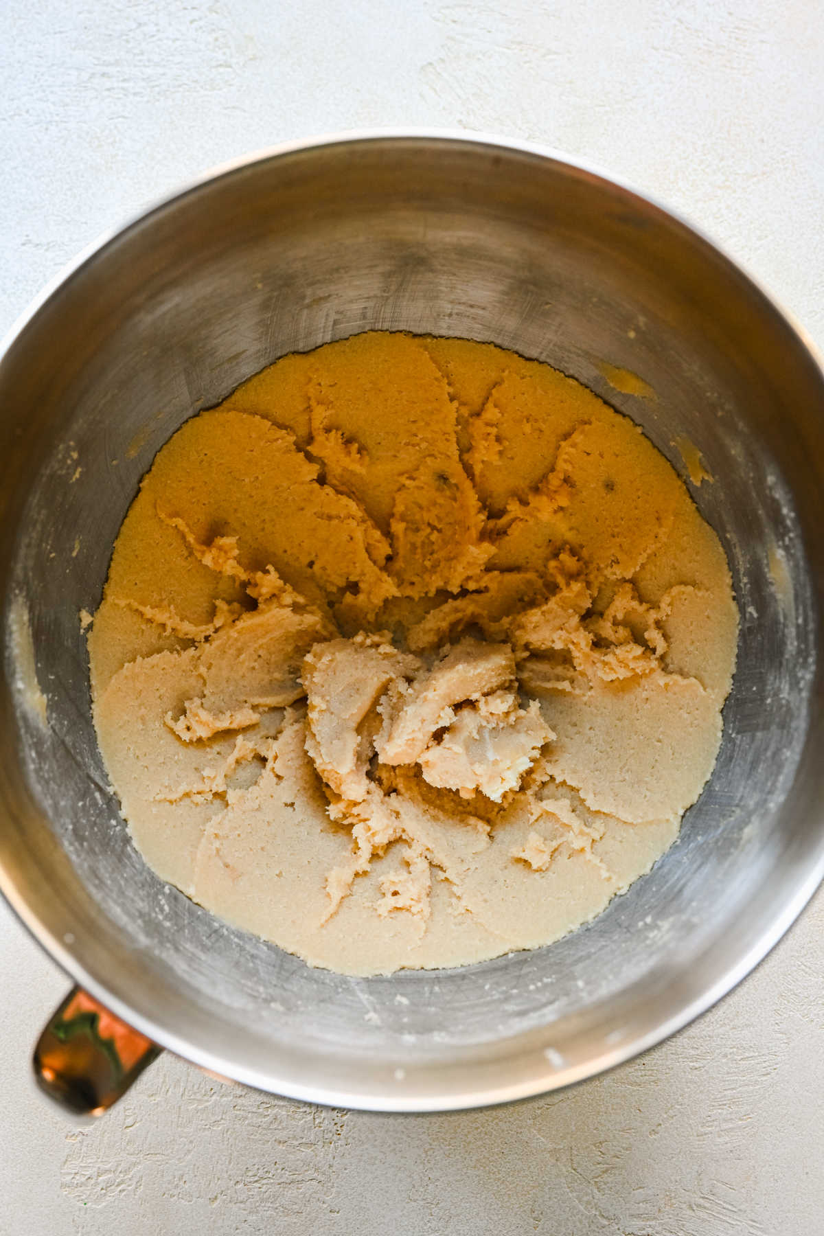 Creamed butter and sugar in a silver mixing bowl.