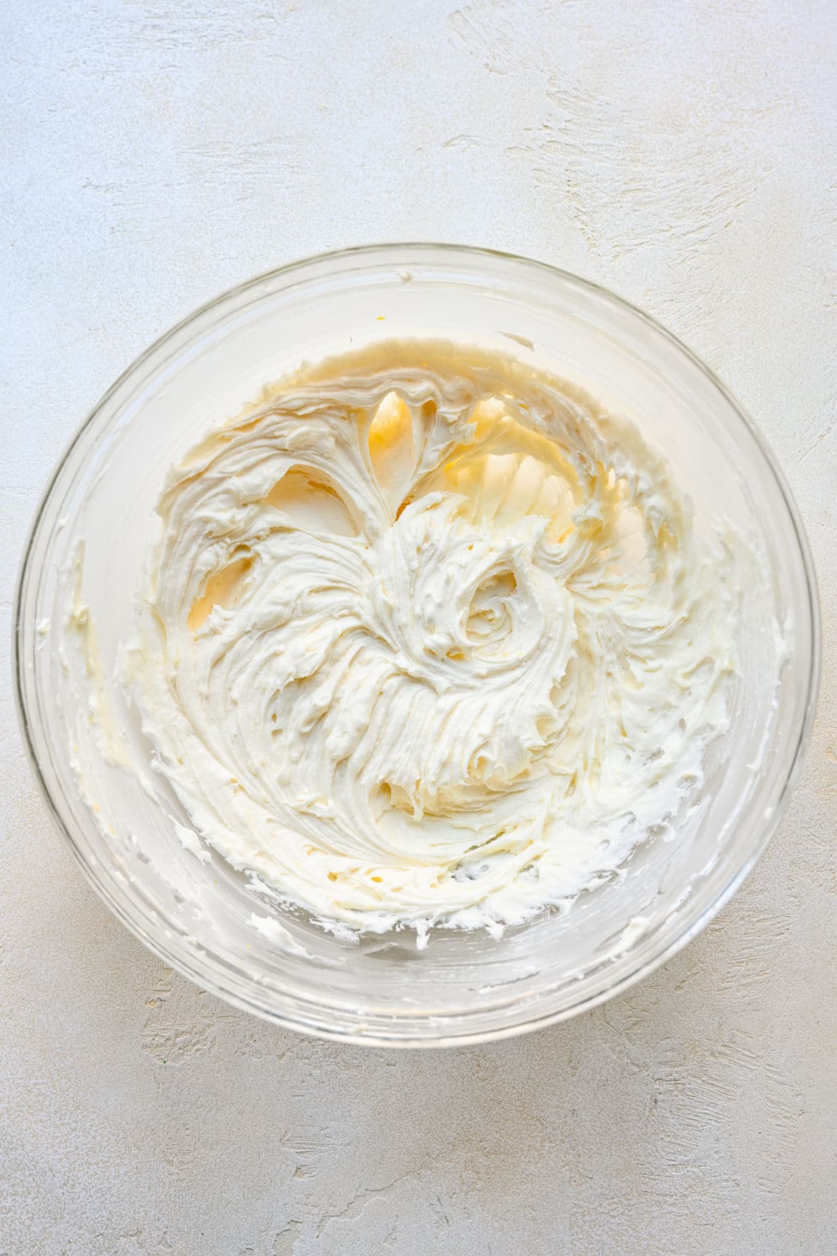 Creamed butter and powdered sugar in a glass mixing bowl. 