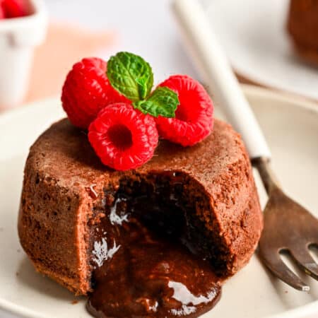 A Nutella molten lava cake on a white plate next to a fork.