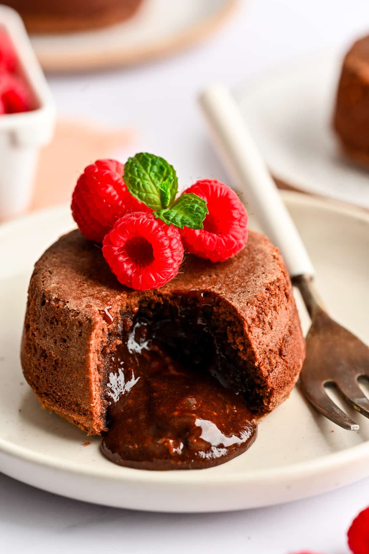 A Nutella molten lava cake on a white plate next to a fork.