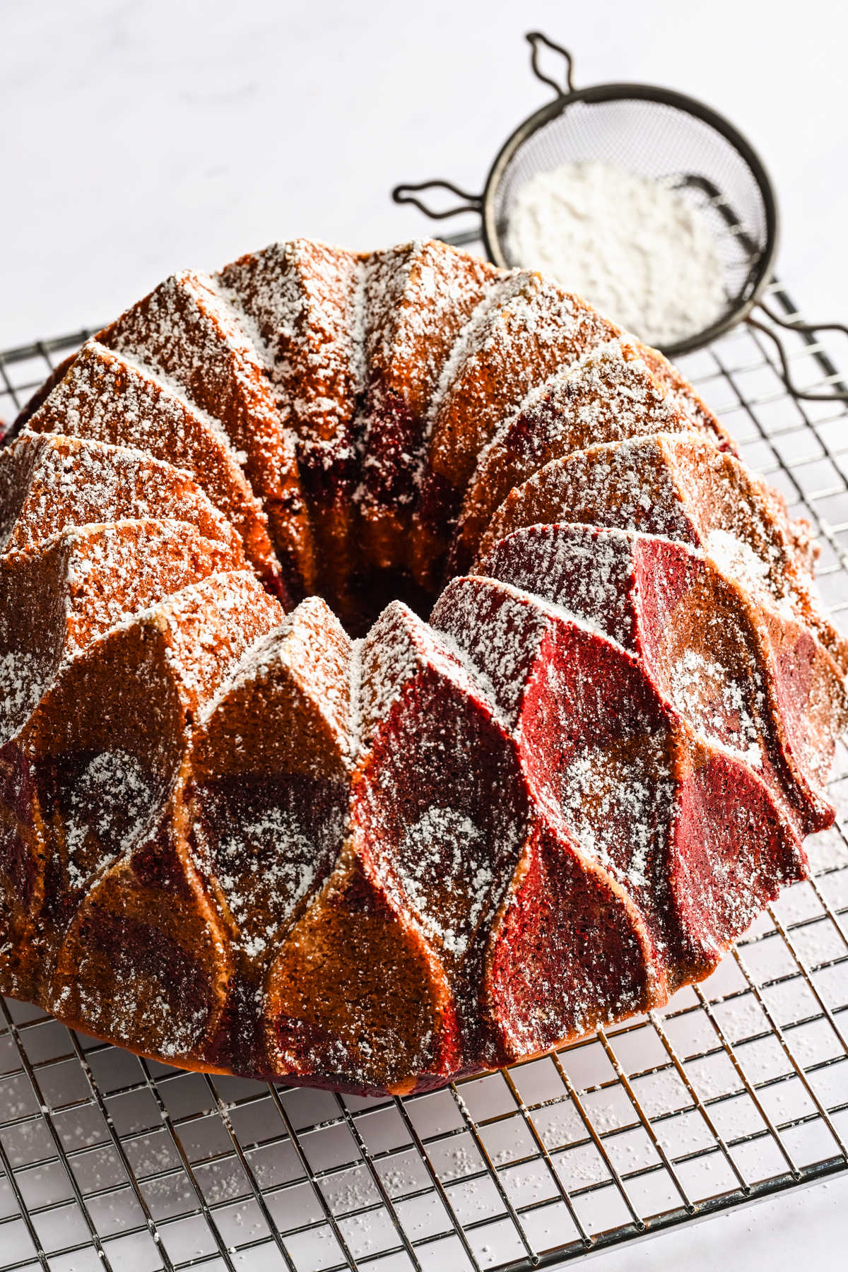 A red velvet marble cake dusted with powdered sugar.