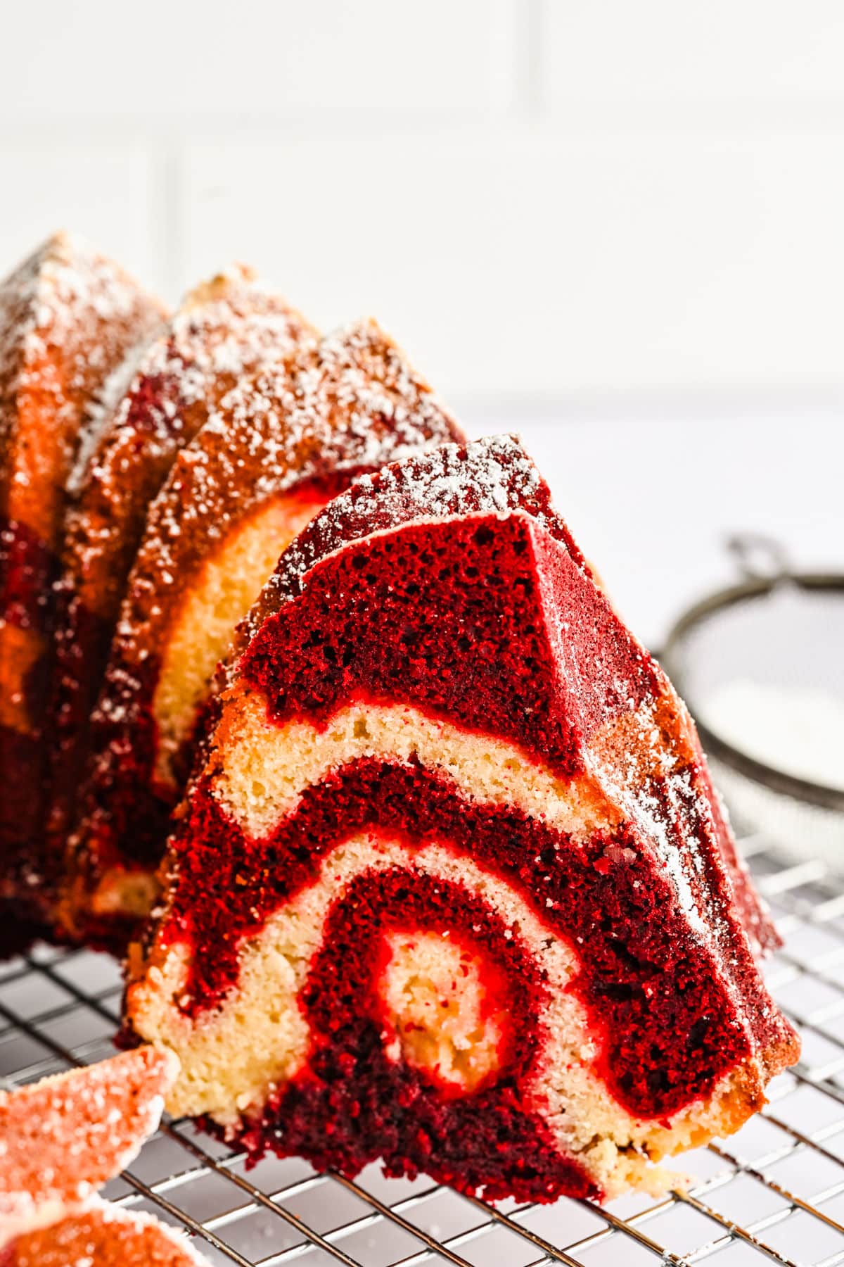 A cut section of red velvet marble cake on a wire cooling rack. 