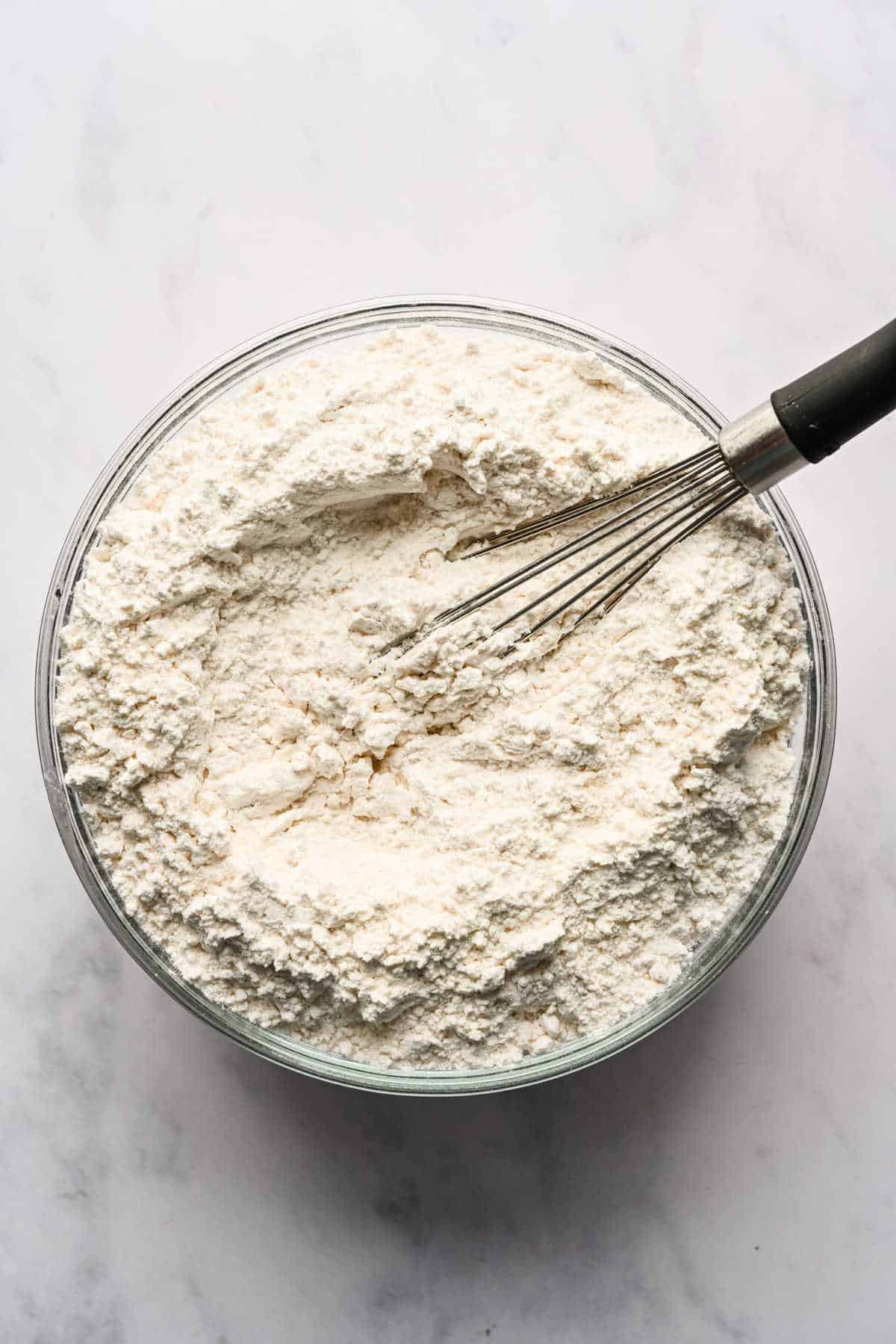 Dry ingredients for red velvet marble cake whisked together in a glass mixing bowl. 