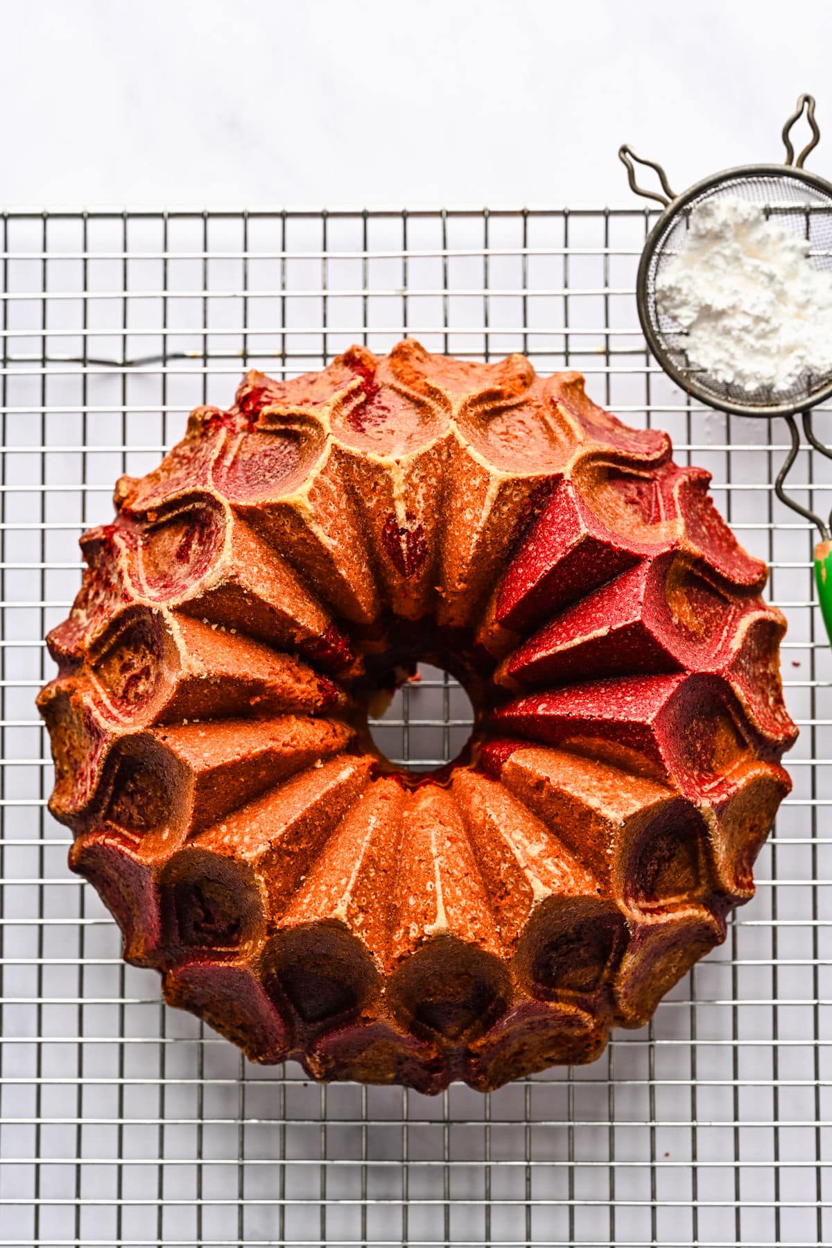 Baked red velvet marble cake on a wire cooling rack. 