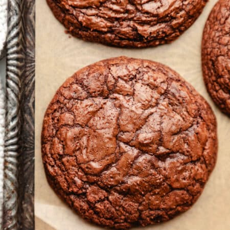A brownie cookie at the bottom edge of a vintage baking sheet.